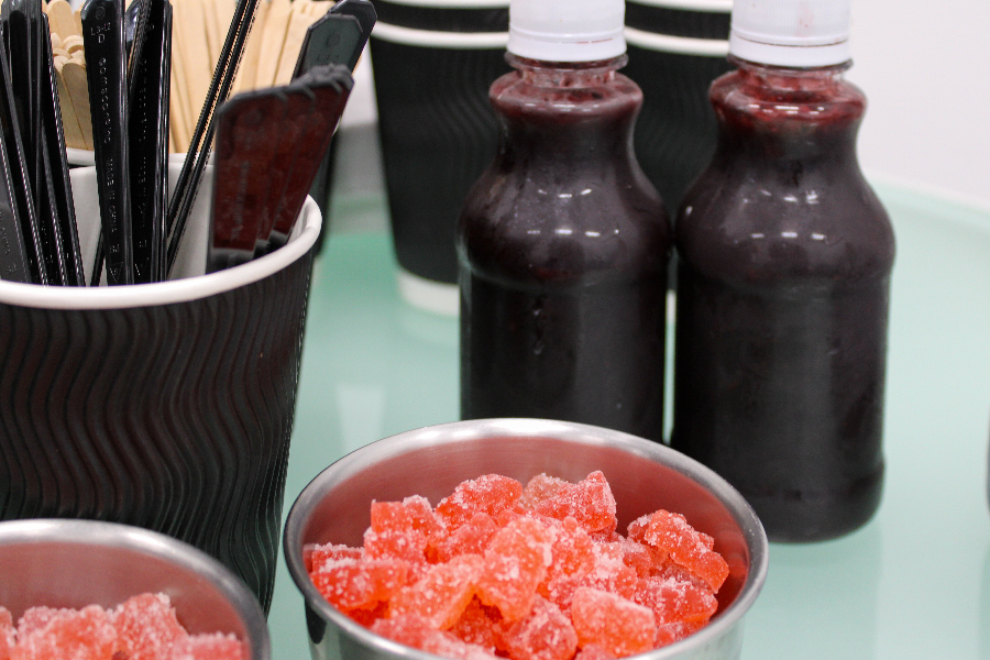 Muestras de gomitas y salsa tipo chamoy sobre una mesa.
