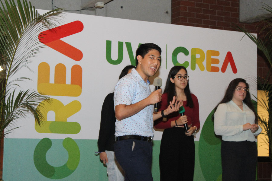 A man and woman up on stage holding up a product and talking into a microphone.