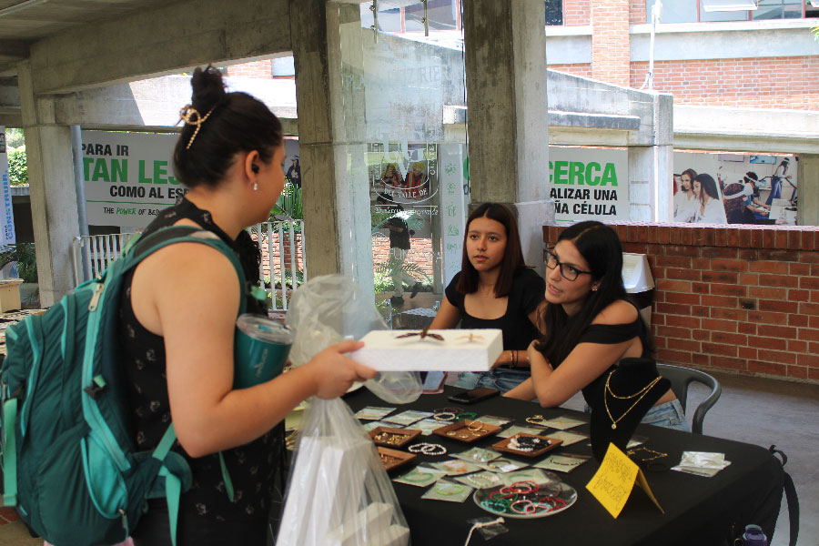 Dos mujeres vendiendo productos a una mujer. 