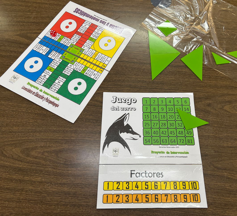 Foto de una mesa color café sobre la cual están dos juegos de mesa, uno llamado “Juego del zorro,” y otro “Güicha y las matemáticas.”