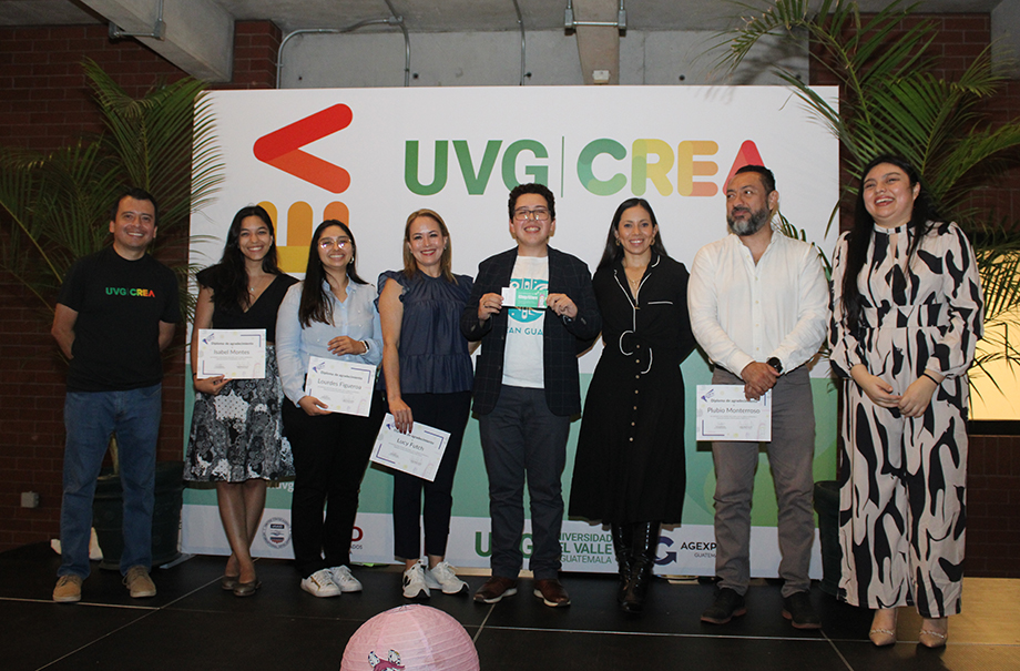 Eight people on a platform in front of room.