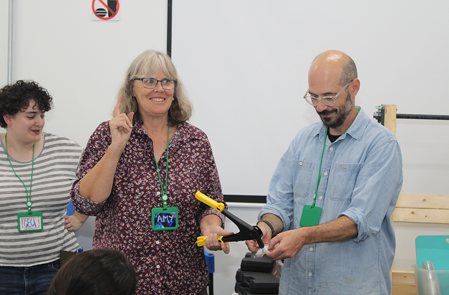Three individuals leading demonstration in creating in front of room.