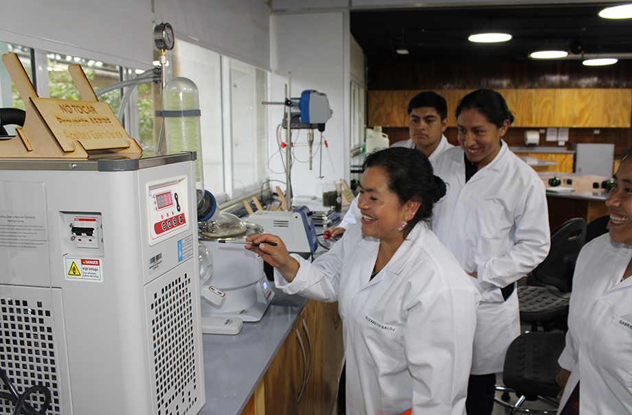 Three people working on a piece of lab equipment