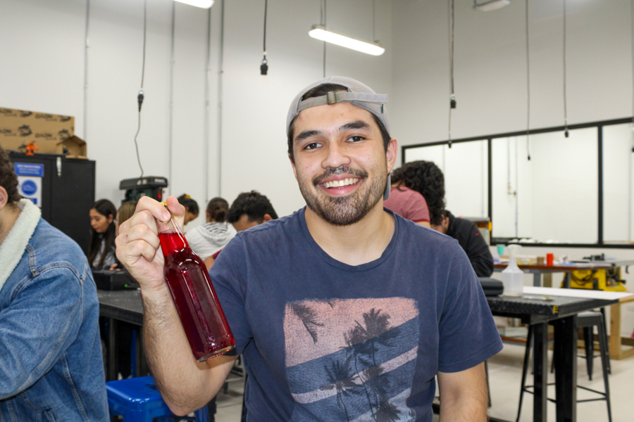 A seated man with a beverage in his hand.
