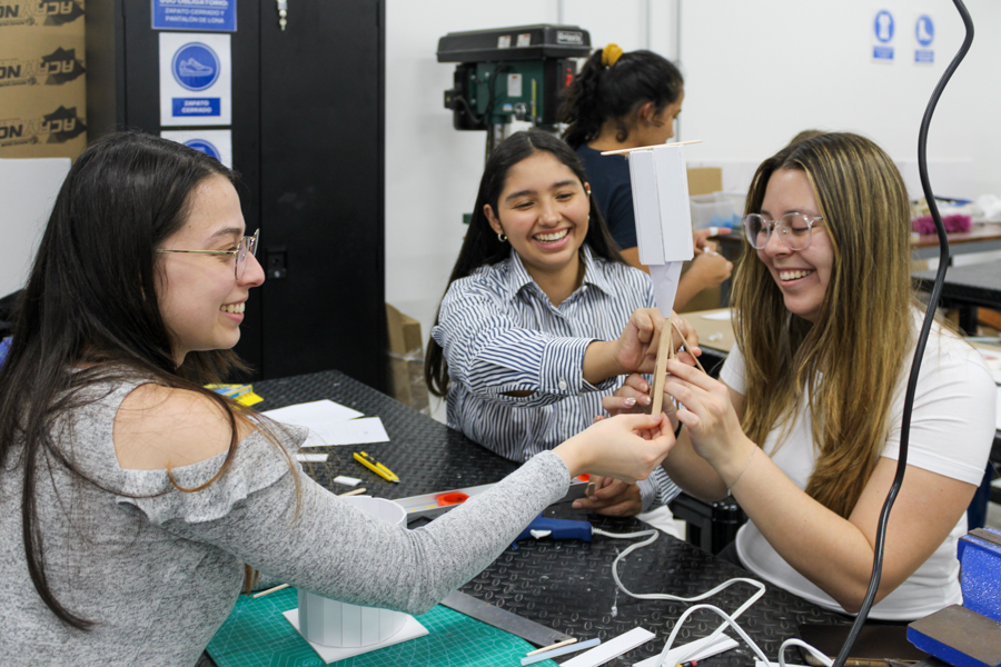 Tres mujeres sentadas sosteniendo un prototipo.