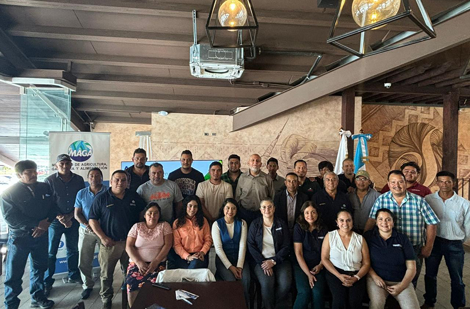 Thirty people in room smiling at the camera